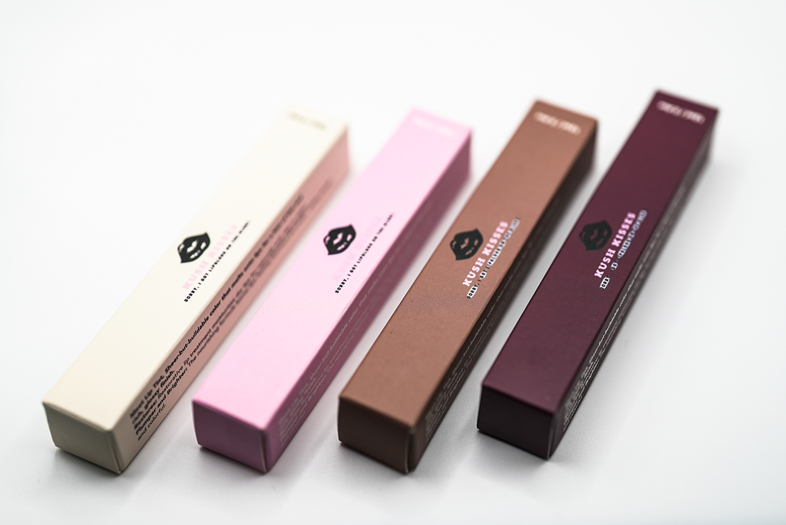 Original Kush Kisses Baby Peach, Baby Pink, Baby Brown and Brown lip gloss packaging